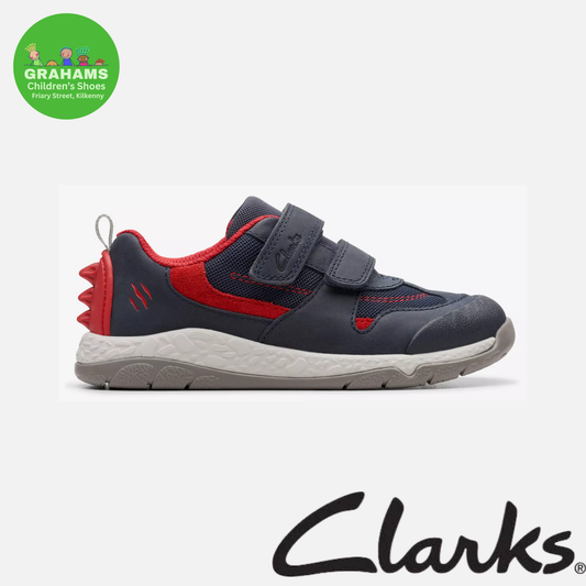 A Clarks toddler sneaker in navy blue and red, featuring a hook-and-loop strap closure and a textured sole, shown against a light gray background with the Clarks logo at the bottom.